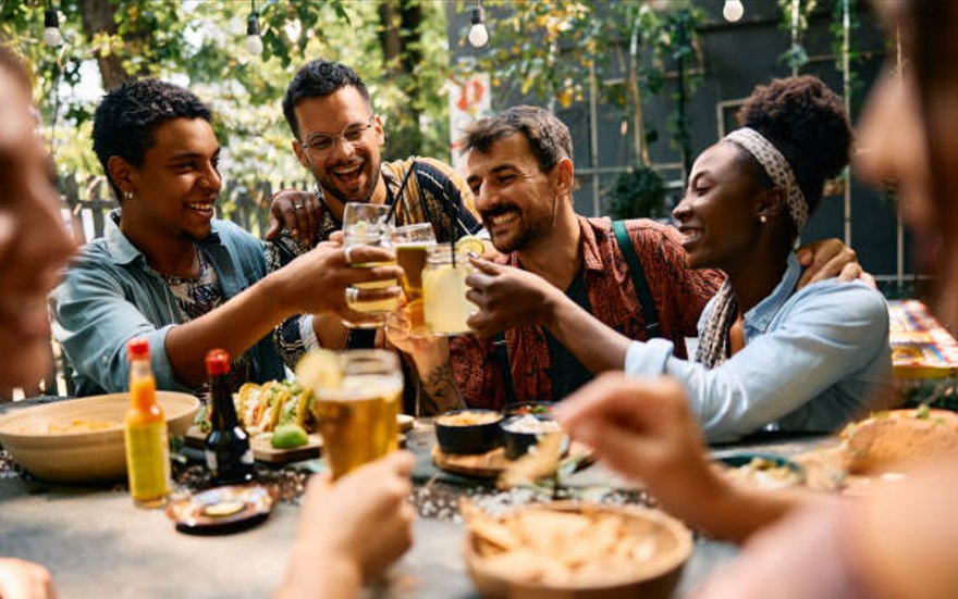 A group of coworkers toasting drinks together at an outdoor company event