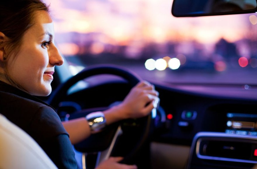 A driver behind the wheel at dusk
